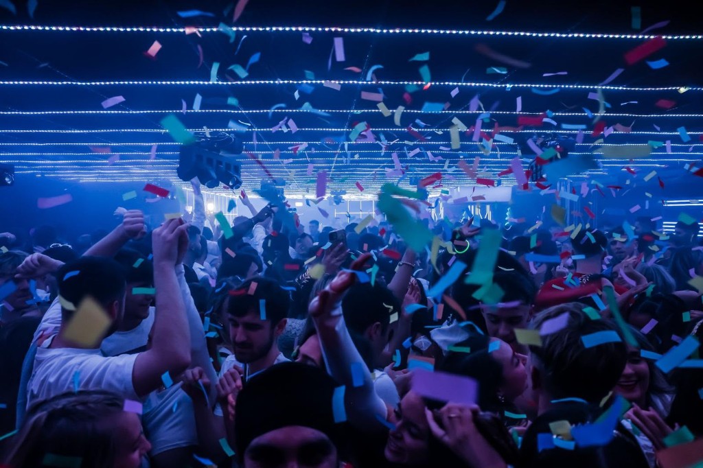 Crowd under purple LED grid ceiling at MN1