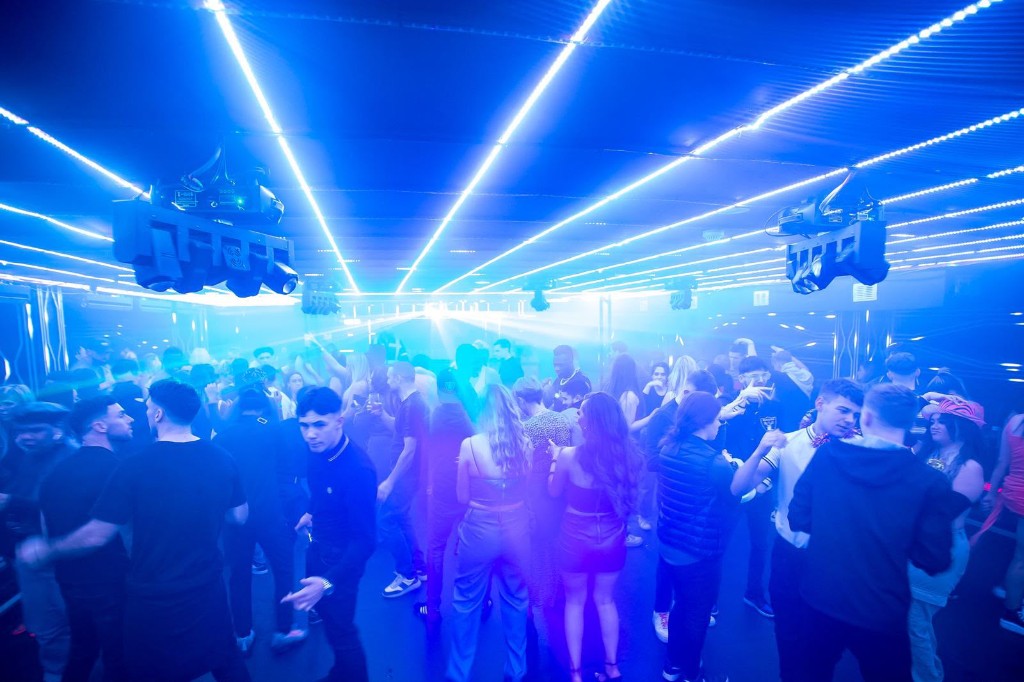 Dancefloor with blue lasers cutting through haze