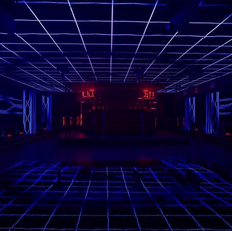 Circular chandelier lights and laser beams over the crowd