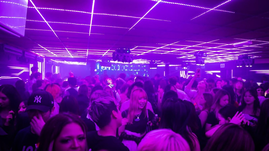 Performer in red lighting inside lit cage frame