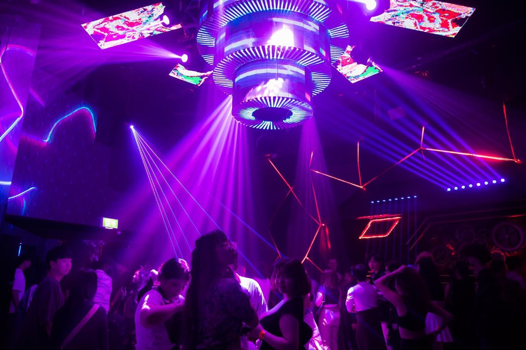 Crowd under blue spotlights and ceiling grid